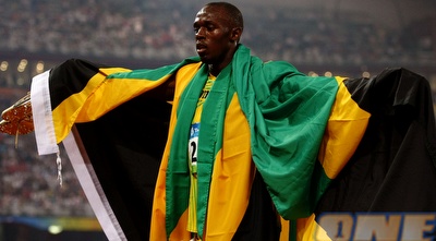 אוסיין בולט עטוף בדגל הג'מייקני (GettyImages)