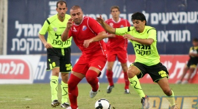 ערן לוי מנסה בכל כוחו להשאיר את הכדור בשליטה של חיפה מול אלמוג כהן (קובי אליהו) ערן לוי מנסה בכל כוחו להשאיר את הכדור בשליטה של חיפה מול אלמוג כהן (קובי אליהו)