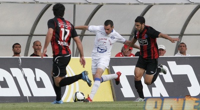 ליאור ראובן מנסה לשמור על הכדור בין שחקני חיפה (שי לוי) ליאור ראובן מנסה לשמור על הכדור בין שחקני חיפה (שי לוי)