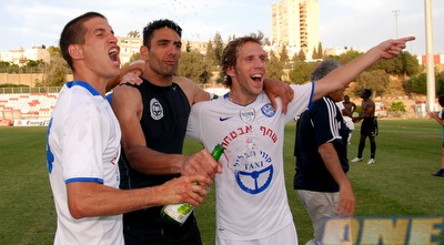 שחקני עכו חוגגים עם השמפניות. נשארו בליגה (שי לוי) שחקני עכו חוגגים עם השמפניות. נשארו בליגה (שי לוי)